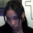 Pixelated static image of a person with dark hair and blue eyes wearing a black top against a light background.