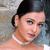 Static 50x50 pixel icon showing a close-up of a person with dark hair, pearl necklace, and light skin tone against a blurred background.