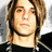 Pixelated image of a person with light brown hair and dark clothing, alongside green pixelated text on black background.