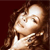 A pixelated close-up of a person with long brown hair, wearing a white top, against a dark red background.