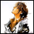 Pixelated image of a character with brown hair and orange skin wearing a white and black outfit against a white background.