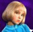 Two side-by-side animated frames of a pixelated cartoon character with blonde hair and blue clothing against a purple background, displaying subtle facial expression changes between frames.