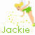 Pixelated cartoon fairy with blonde hair and green outfit holding a wand, surrounded by yellow sparkles on white background.