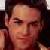 Pixelated close-up of a person's face with dark hair, light skin tone, and closed eyes against a blurred background.