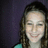 A person with long brown hair wearing a teal top against a dark purple background, shown in three views where the rightmost view is cropped.