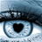 Pixelated eye with black heart-shaped pupil, dark eyelid, and light blue-gray iris against blurred background.
