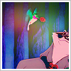 Pixelated image of a hummingbird with green wings and pink body holding a red flower, positioned above a person in sunglasses and a pink shirt against a multicolored striped background.