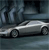 A silver sedan with black wheels is positioned on a reflective surface under a dark, blurred background with vertical light streaks.