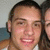 Pixelated close-up of two people with dark hair, one in front showing a smiling face and light-colored clothing against a blurred background.