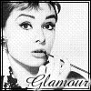Black-and-white pixelated portrait of a person with short hair, hand near mouth, wearing a patterned garment with visible text.