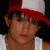 Static 50x50 pixel icon showing a person wearing a red and white baseball cap, visible from the shoulders up against a dark background.