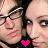 Static 48x48 pixel buddy icon showing two close-up faces with a pink heart symbol at the bottom center, rendered in low-resolution pixel art style with visible dithering and color blending.