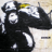Pixelated black and white figure with yellow accent on head, holding a long object against light background.