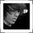 Pixelated grayscale image of a stylized face with closed eyes and flowing hair against black background, framed by white border.