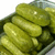 Green dill pickles in a glass jar with text 'Dill Pickle' on the right side.