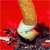 A pixelated image shows a golden cylindrical object emitting smoke against a red background with dark smoky patches.