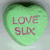 Four heart-shaped candies in green, purple, pink, and a text with 'happy valentines day!' displayed on a light background
