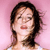A pixelated portrait of a person with dark hair against a pink background, wearing a light-colored top.