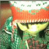 Animated figure in green knit sweater and orange-and-white striped hat with white snowflake patterns, holding a yellow object near the face.