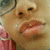 A close-up of a person's face with a pink garment visible on the left side, showing subtle changes in mouth position across frames.