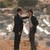 Two figures in dark suits stand side-by-side against a blurred background with light and dark tones.