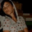 A person in a light-colored hoodie with dark patterns stands against a dark background, next to red pixelated text reading "how could I live without her?".