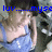 Pixelated image of a person with long brown hair wearing a light blue sleeveless top, overlaid with blue text reading 'luv...myse' against a dark background.