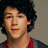 Pixelated portrait of a person with curly dark hair wearing red and gray clothing, next to bold red text on black background.