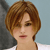 Pixelated close-up of a person with short brown hair, light skin, and a white top against a light blue background.