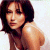 A pixelated image of a woman with shoulder-length dark hair, bare shoulders, and light skin against a white background. To the right is green text on a dark green background.