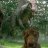A pixelated static image shows a blurred figure in a natural setting with green foliage and a brown trunk-like shape.