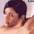 Static pixelated image of a person with dark hair in profile view, showing upper body and shoulder area against light background.