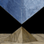 A pixelated image shows a light brown pyramid on a beige base against a black background, with a blue sky above.