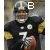 A football player in a black uniform with yellow accents holds a brown football, wearing a helmet and smiling.