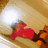 A pixelated red figure with green accents lies on a beige background beneath a bright white circular light source.