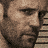 Pixelated image of two men's faces above yellow chevron arrows and text reading AMES DEATH RACE on black background.