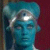 Pixelated static image of a blue-toned humanoid figure with closed eyes and a smooth head, set against a dark red background.