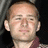Pixelated image of a person with short hair and light skin wearing a maroon-collared shirt, next to pink text reading 'harry loves you' on black background.