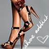A close-up of a person's legs wearing high-heeled sandals with black straps and silver accents, positioned against a gray background with white text and a heart symbol.