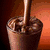 A split-screen image shows chocolate pudding being poured on the left and bacon strips on the bottom, with text describing their qualities.