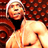 Pixelated static image of a person with light hair wearing a dark top against a red patterned background, rendered in low-resolution 256x256 pixels.