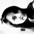 Pixelated grayscale icon of a character with short dark hair, wide eyes, and an open mouth against a white background.