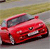 Red sports car with dark tinted windows and silver wheels on a blurred background, rendered in pixelated style with visible compression artifacts.