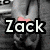 A grayscale image of a person holding a pink heart-shaped object, with the text "Zack" overlaid in bold white letters.
