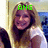 A woman with long light brown hair wearing a white shirt smiles at the camera, with green text above her head changing from 'ANG' to 'ME!'