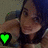 Pixelated image of a person with brown hair and dark clothing holding a bright green heart-shaped icon against a muted background.