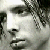 Pixelated grayscale image of a person with dark hair and a light-colored shirt, partially obscured by low resolution and compression artifacts.