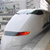 Pixelated static image of a white train with red accents on a blurred background.