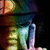 Pixelated figure in dark blue top and light blue pants, standing against dark background with green and orange accents.