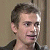 Pixelated image of a person with short brown hair wearing dark clothing against a light background, next to green text reading 'Original Icons .com' on a solid green backdrop.